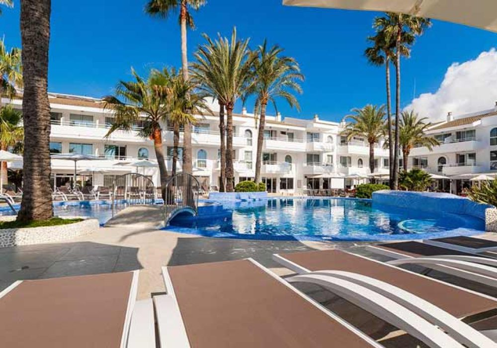 Zona de relax con piscina y tumbonas en Hotel Hoposa & Apartaments Villaconcha